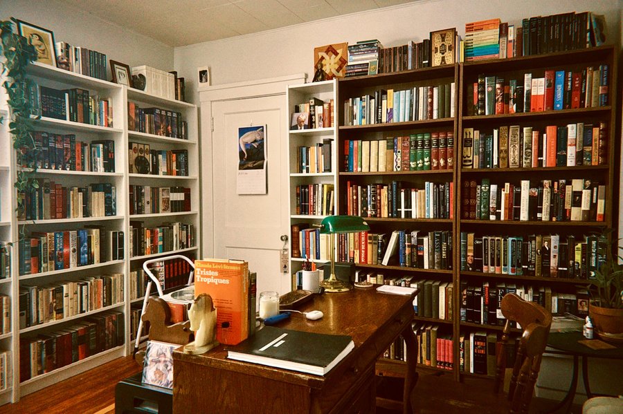 A home library with floor-to-ceiling bookshelves and a writing desk